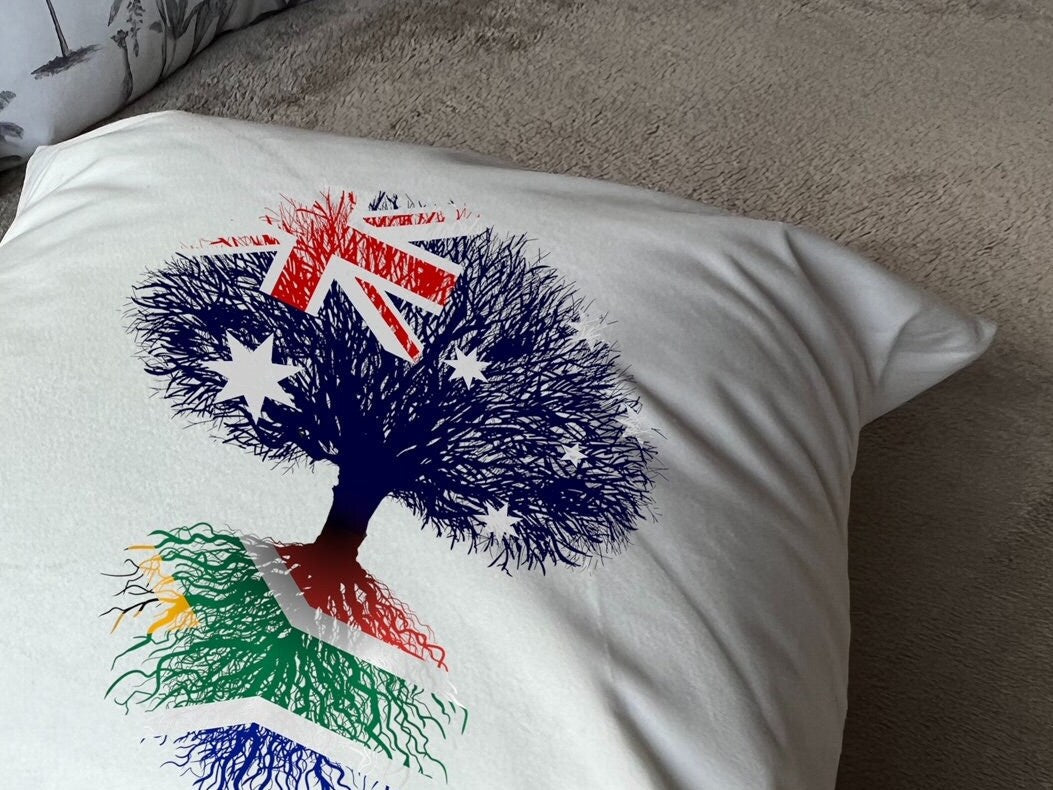South African heritage cushion Australian flag tree with South African flag roots. Plush white cushion, ideal gift.