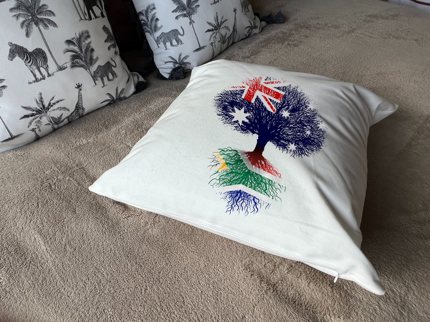 South African heritage cushion Australian flag tree with South African flag roots. Plush white cushion, ideal gift.